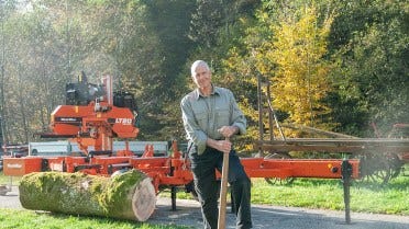 Un ingénieur à la retraite scie et travaille le bois dans les Alpes françaises 
